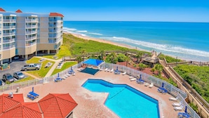 Un hotel con piscina, acceso a la playa y vista al océano.