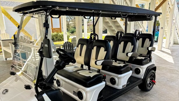 A golf cart with three seats, a steering wheel, and a black roof. - Anchor Forty-Five: Coastal home with large deck, close to beach and local attractions (Oak Island)