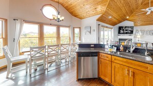 A spacious kitchen with wooden ceiling beams, a dishwasher, and a sink. - Reel 'Em Inn 403: Gorgeous, outdoor pool, spacious carport, decks (Avon)