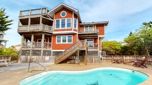 A multi-story house with a swimming pool, wooden deck, and outdoor furniture. - Reel 'Em Inn 403: Gorgeous, outdoor pool, spacious carport, decks (Avon)
