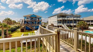 A coastal residential area with multi-story houses, a wooden deck, and a swimming pool.