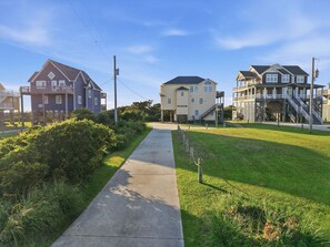 A residential street with houses, a sidewalk, and a grassy area. - Soundfront house with private dock, hot tub, WiFi, & beautiful views (Frisco)