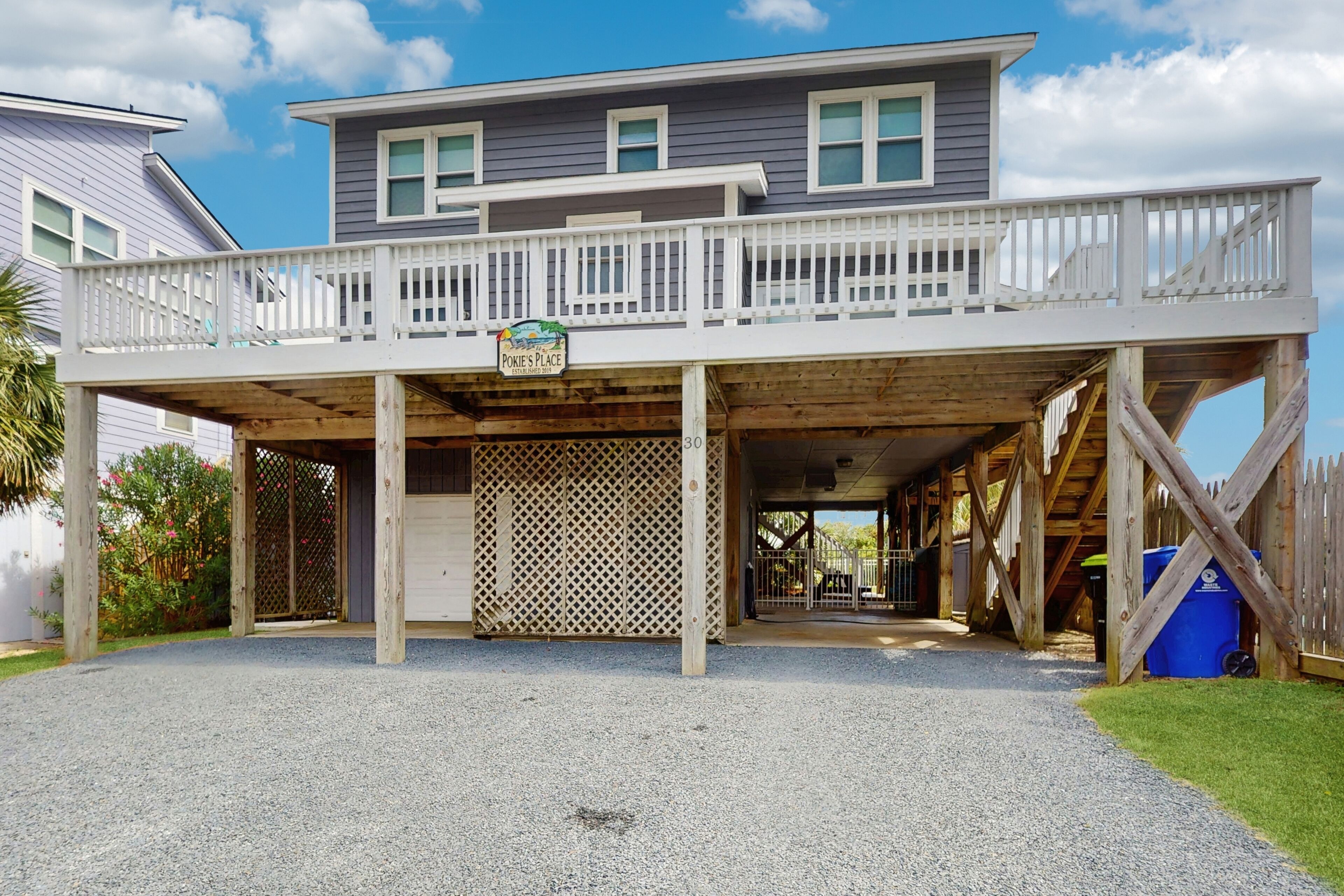 A two-story house with a covered porch and a sign that reads "Pokie's Place."