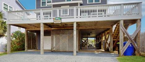 A two-story house with a covered porch and a sign that reads "Pokie's Place."
