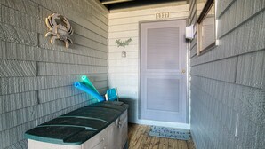 A small room with a wooden floor, a bench, and a door marked with the number 1317. - Oceanfront condo with elevator, private beach, ocean view, community pool, grill (North Topsail Beach)