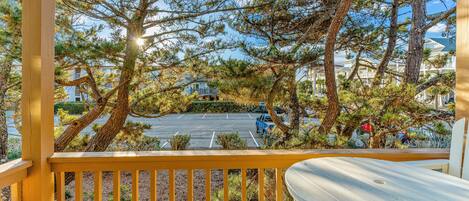 A wooden deck with a view of a parking lot and houses in the background.