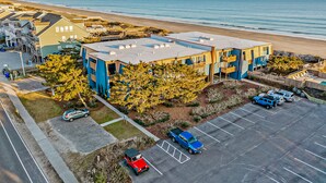 Ein Küstengebäude mit Parkplatz, direkt neben einem Strand.