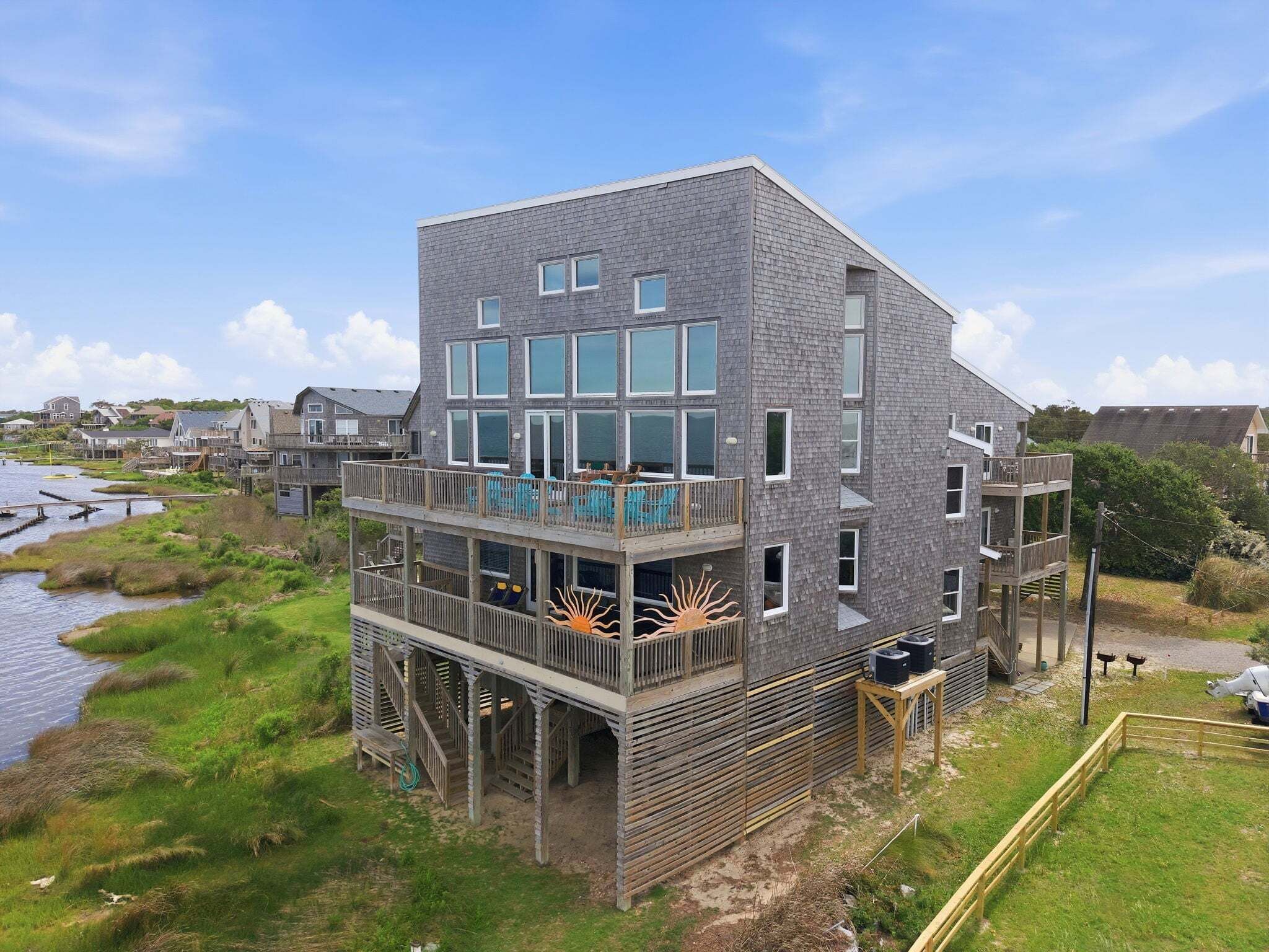 A multi-story building with balconies, a waterfront view, and a dock.