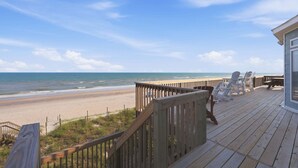 A wooden deck with beach views, a railing, and beach chairs. - Oceanfront home with direct beach access, community pool & private hot tub (North Topsail Beach)