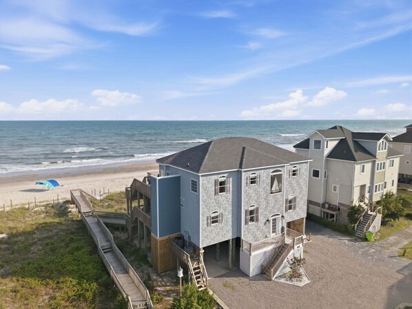 Une zone résidentielle côtière avec des maisons, une plage et un ciel dégagé.