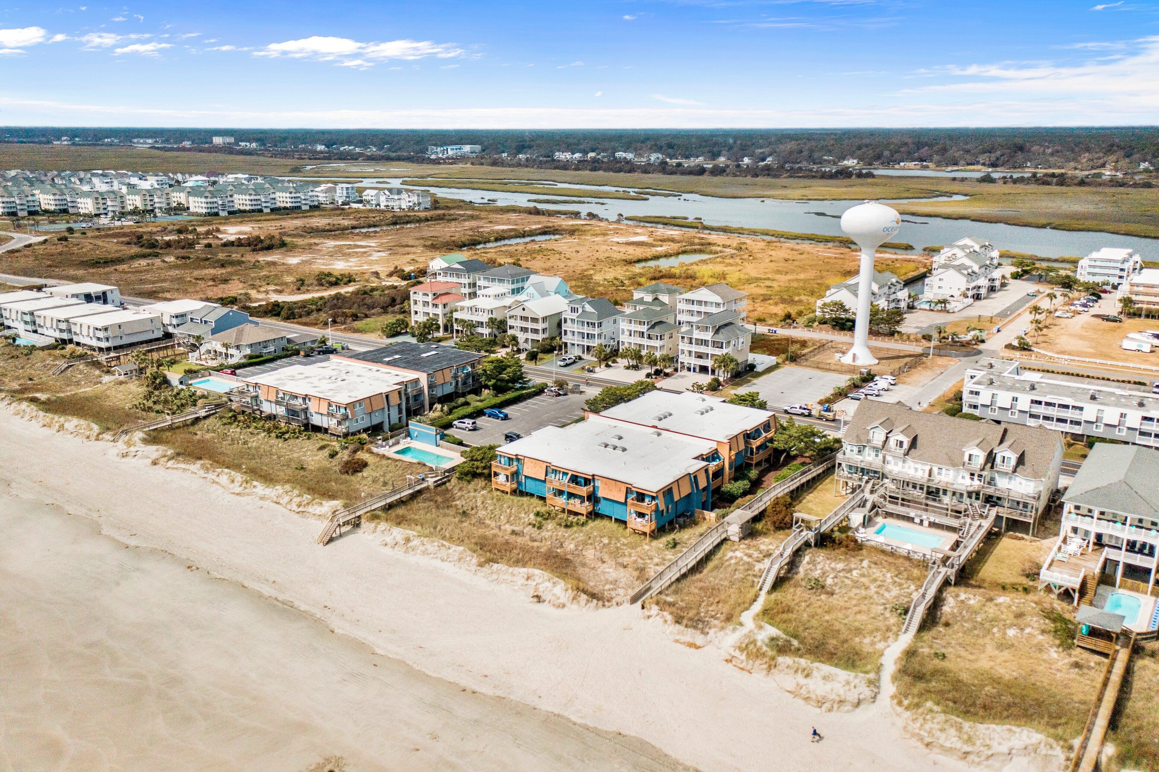 Un quartier résidentiel situé sur la côte, avec des propriétés donnant sur la plage, un château d’eau et un port de plaisance.