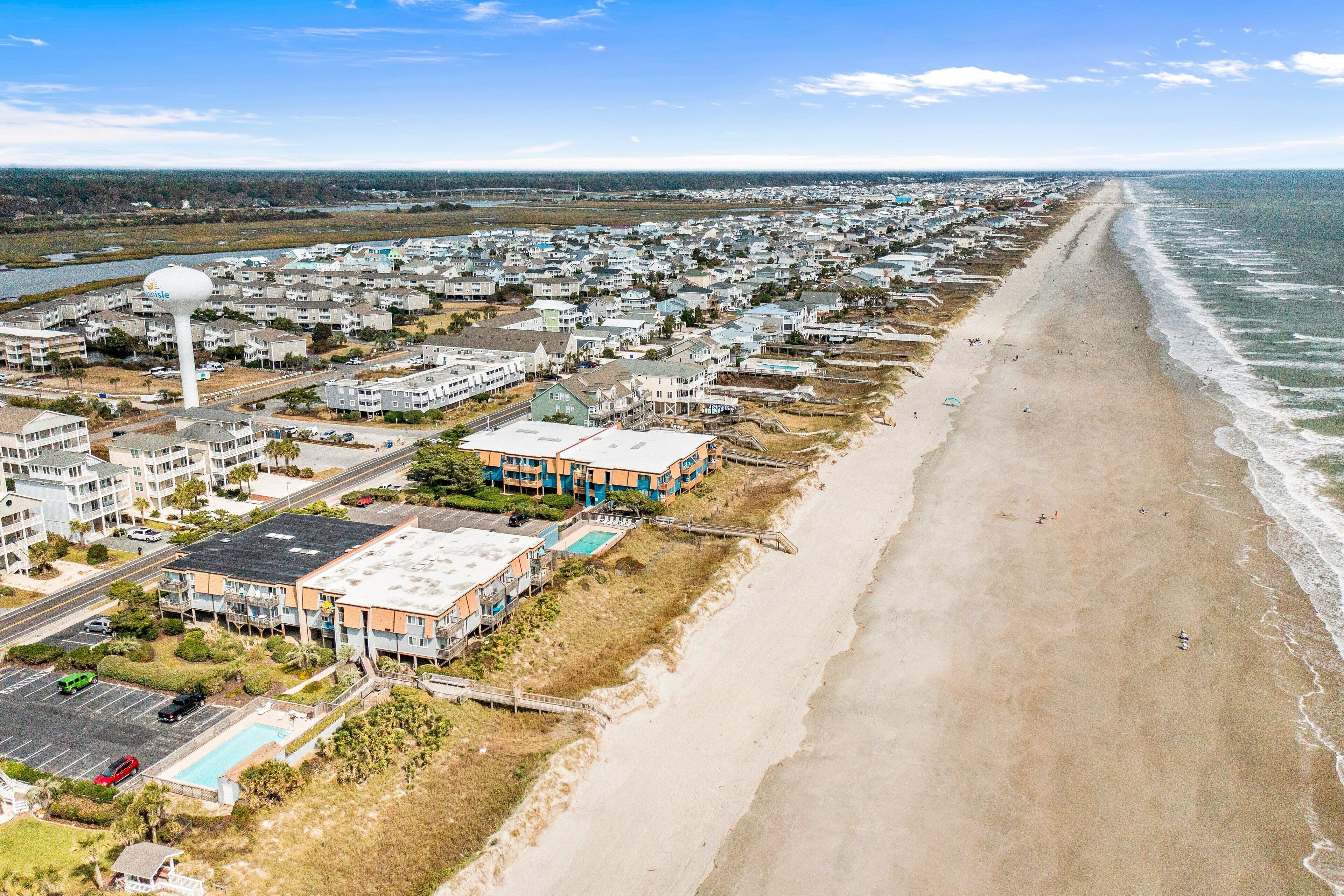 A coastal residential area with beachfront properties, a swimming pool, and a water tower.