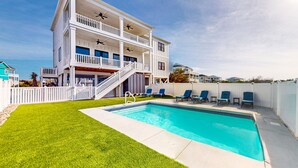 A two-story house with a swimming pool, a covered patio, and a staircase leading to the upper floor. - Take Me A-Wave: Water-view, pool, foosball, grill, & two W/Ds (Ocean Isle Beach)