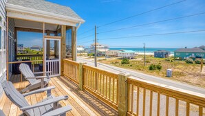 A wooden deck with Adirondack chairs, a covered porch, and a view of the beach and ocean. - Ocean-view beach home - private hot tub, elevator, cook's kitchen - dog-friendly (North Topsail Beach)