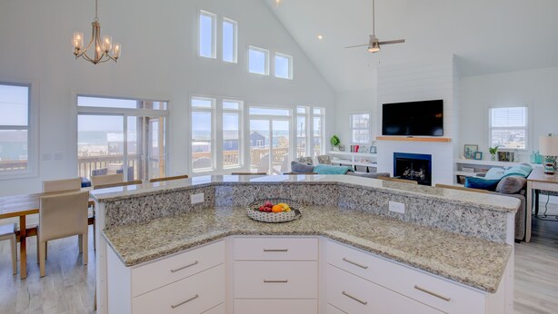 A spacious kitchen with a large island, high ceilings, and large windows offering views of the city. - Ocean-view beach home - private hot tub, elevator, cook's kitchen - dog-friendly (North Topsail Beach)