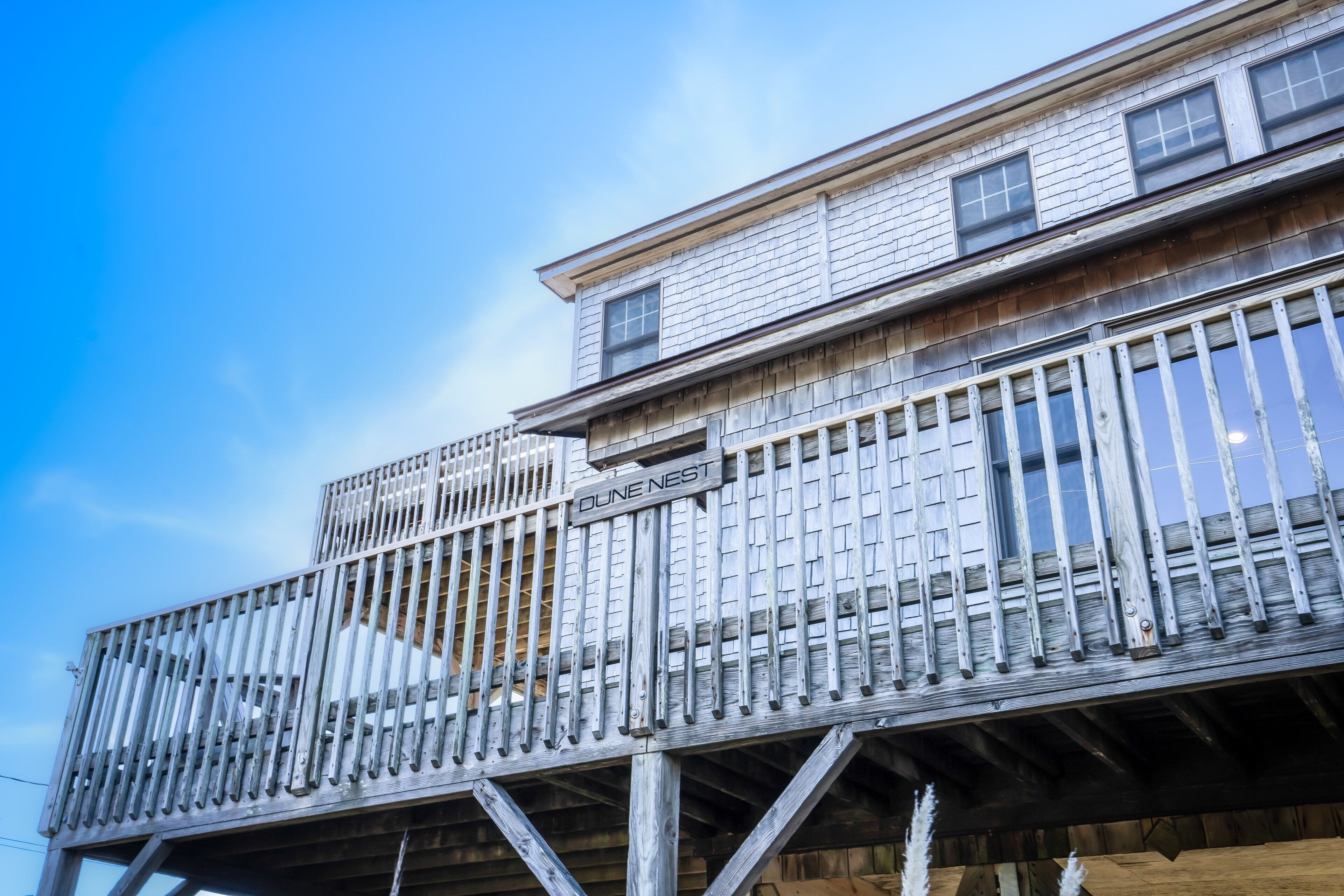 A wooden building with a balcony and a sign that reads "DUNNEST."