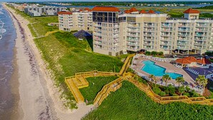 A coastal hotel with multiple buildings, a swimming pool, and a beach. - St. Regis beach condo with ocean-view balcony, pool, gym & restaurant (North Topsail Beach)