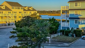 A coastal residential area with multi-story buildings, a visible beach, and a clear sky.