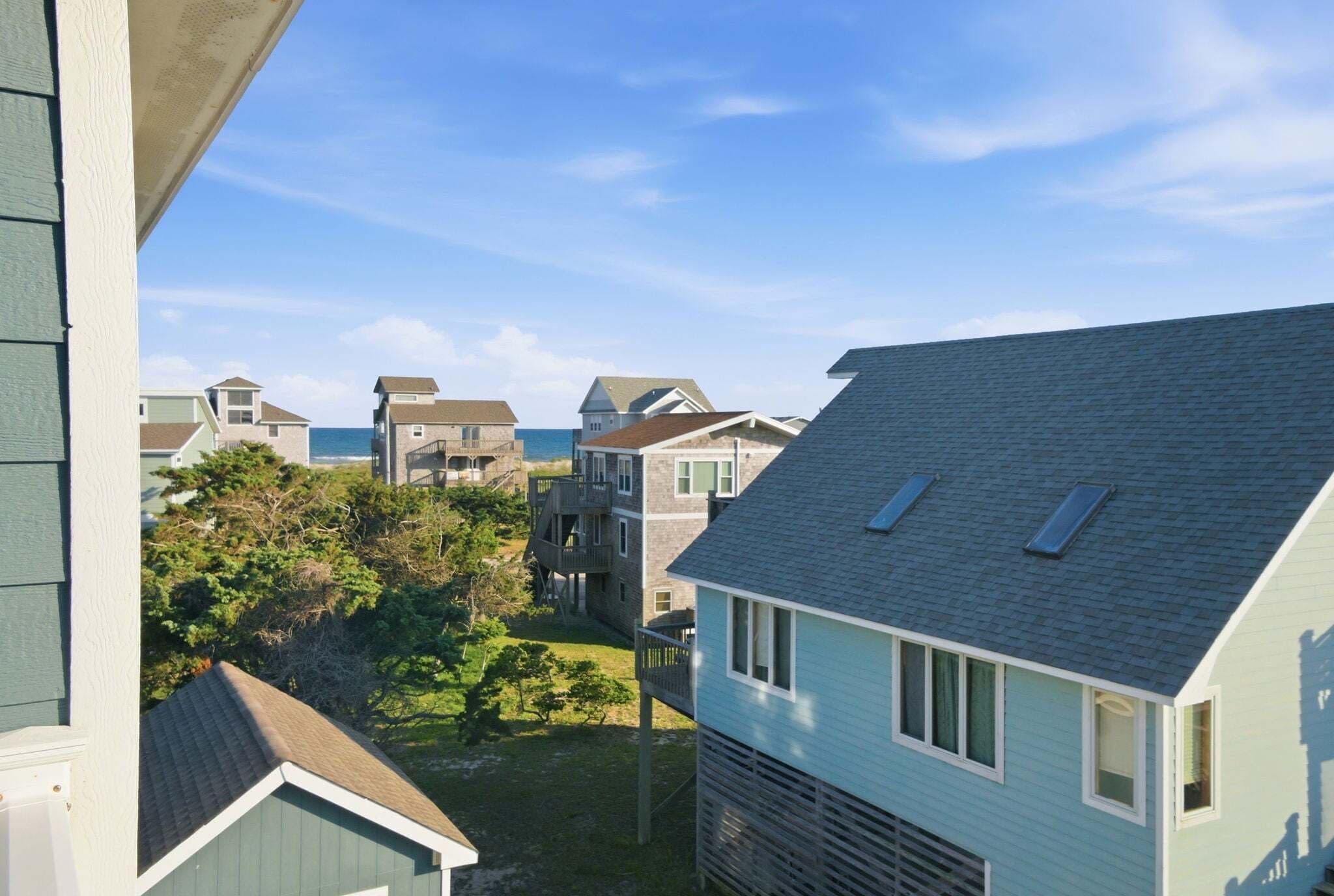 A residential area with houses, a grassy yard, and a clear sky.