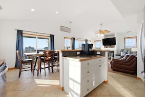A spacious living area with a kitchen, dining table, and a sofa.