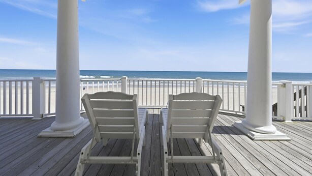 A wooden deck with two white chairs under a white gazebo overlooking the ocean. - Oceanfront, Next door to Pool, Easy Access, Oversized Deck (North Topsail Beach)