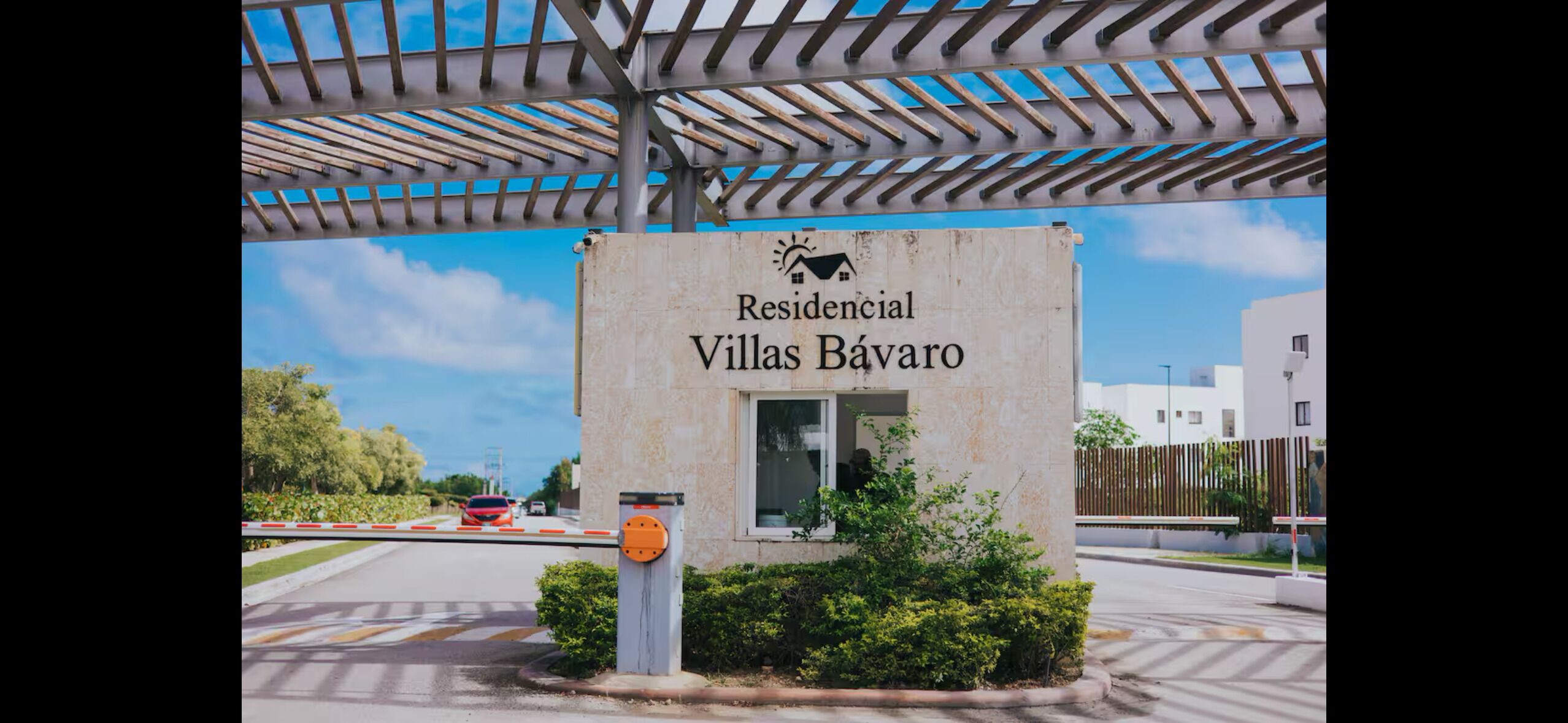 Segnale per 'Residencial Villas Bávaro', con vista chiara sull'ingresso e vialetto recintato.