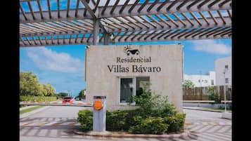 Segnale per 'Residencial Villas Bávaro', con vista chiara sull'ingresso e vialetto recintato.