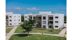 Un bâtiment moderne doté d’une cour intérieure, entourée de pelouses bien entretenues et d’un arbre.