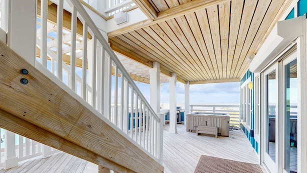 A wooden deck with a white railing, a bench, and a view of the ocean. - Waterfront home with amazing sound view, private pool, hot tub, & game room (Avon)