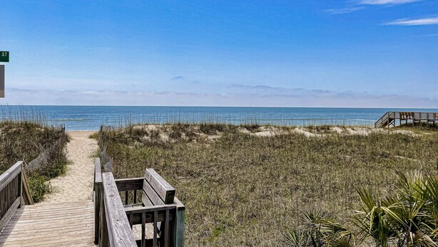 A wooden boardwalk leading to a beach with a clear view of the ocean. - Grams Getaway: Private pool, deck, & patio - walk to the beach (Ocean Isle Beach)