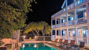 Um edifício com várias andares, varandas, piscina e área de estar ao ar livre.