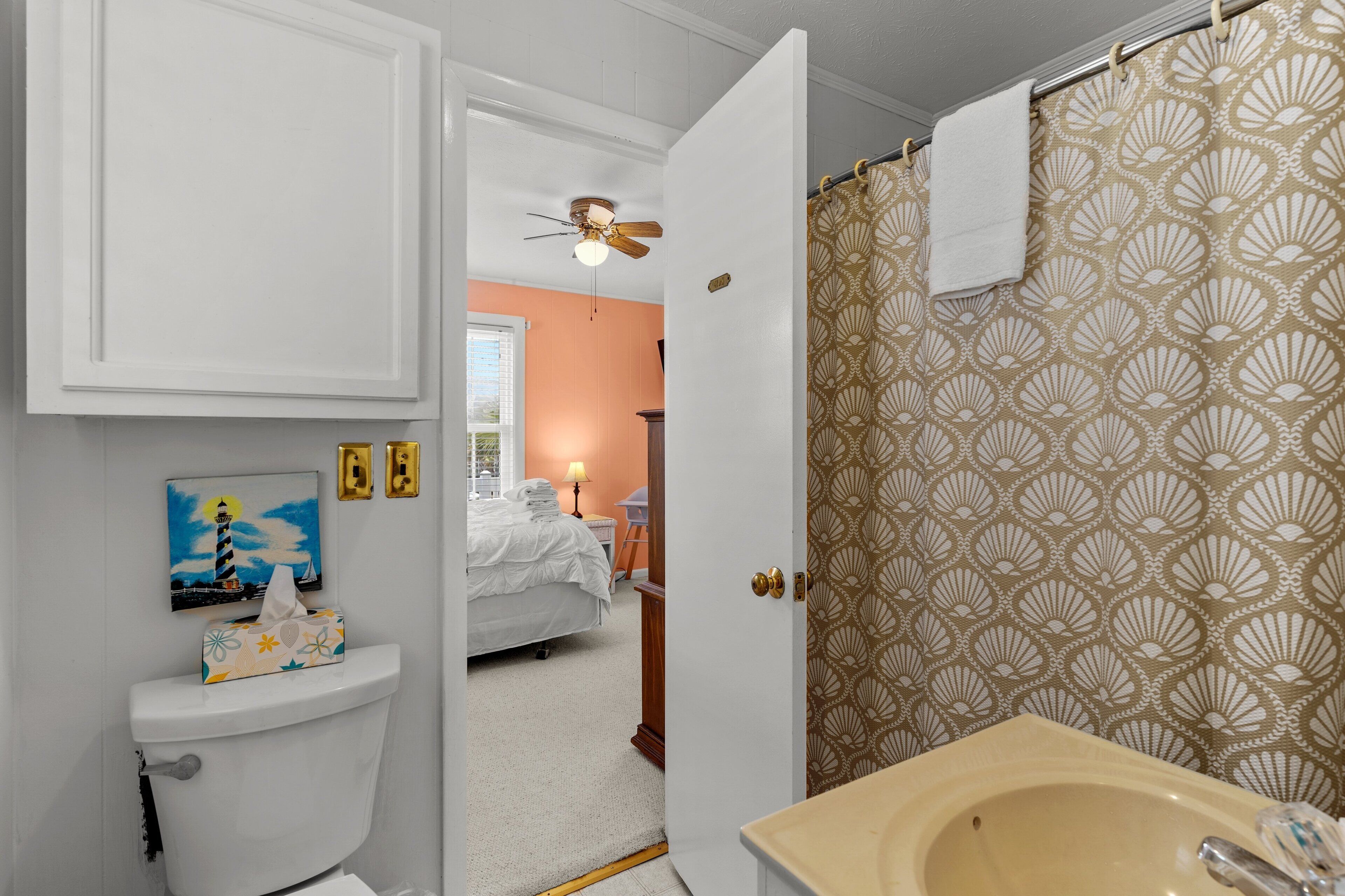 A bathroom with a toilet, sink, and shower curtain.
