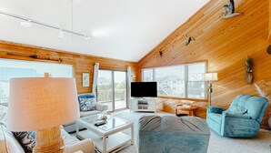 A cozy living room with a television, a blue armchair, and a large lamp. - Beach home near the ocean w/sunny deck, washer/dryer, and central A/C (Frisco)