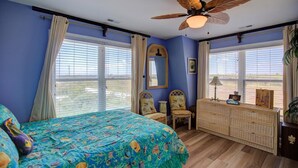 A bedroom with a bed, a ceiling fan, a dresser, and a window with curtains. - Ocean View Duplex in Hampton Colony - Community Pool & Just Steps to the Beach!! (North Topsail Beach)