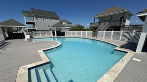 A swimming pool with a wooden deck, a lifeguard stand, and a white fence. - Ocean View Duplex in Hampton Colony - Community Pool & Just Steps to the Beach!! (North Topsail Beach)