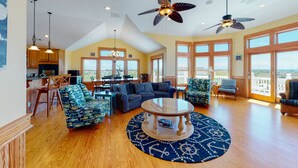 A spacious living area with a large round coffee table, comfortable seating, and a view of the outdoors. - Dog-friendly ocean- & sound-view home with private pool, hot tub, & central AC (Avon)
