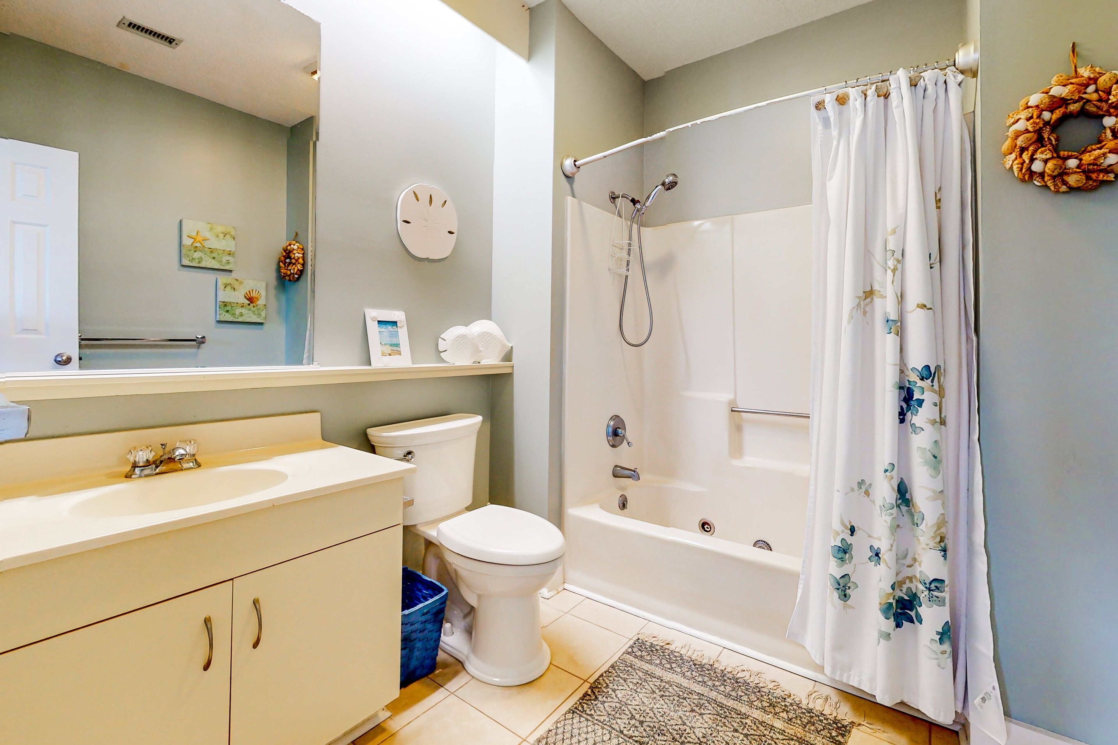 Une salle de bain équipée de toilettes, d’un lavabo, d’une baignoire et d’un rideau de douche.