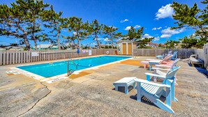 A swimming pool with lounge chairs and a small shed. - Incredible waterfront condo with amazing ocean views, pool, deck, & beach access (Avon)