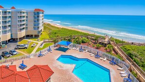 Ein Hotel mit Pool, Meerblick und Parkplatz.