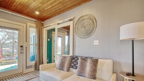 Un salon moderne avec un canapé beige, un élément décoratif mural et une lampe.