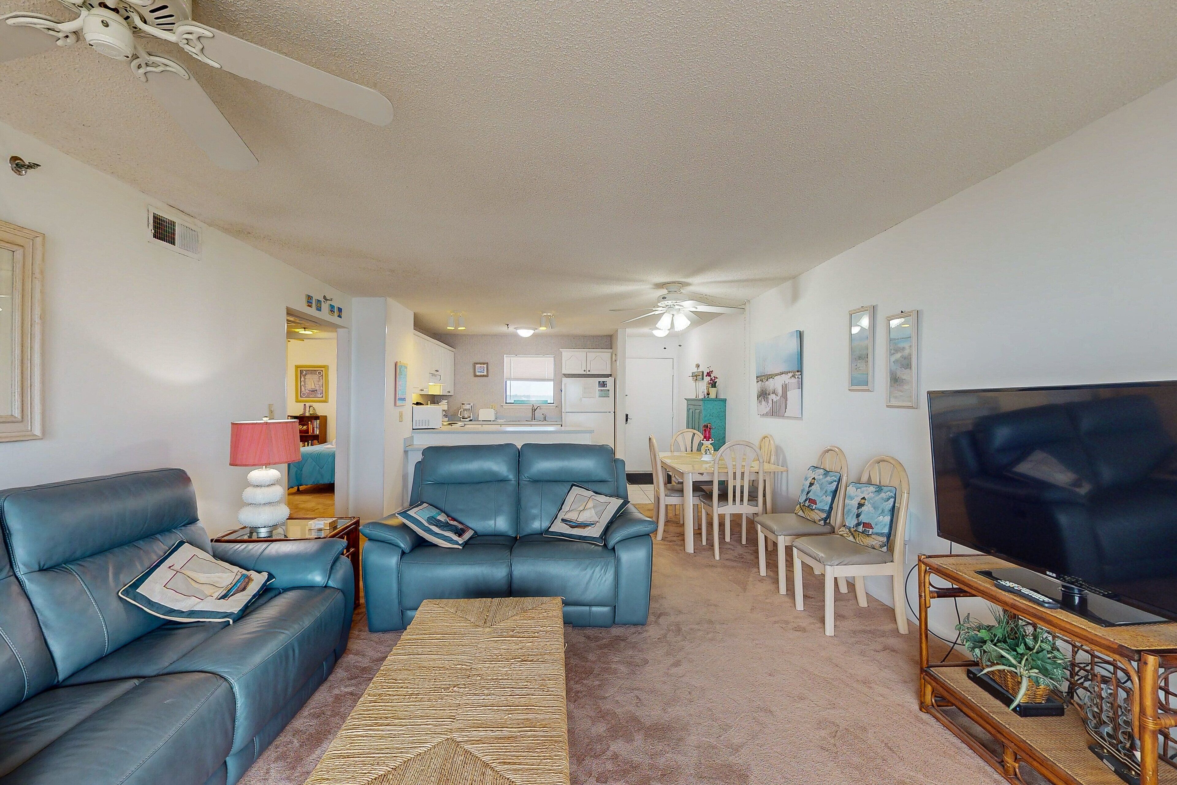 A living room with a sofa, TV, and dining area.