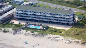 Um hotel com vários andares, piscina e acesso à praia.