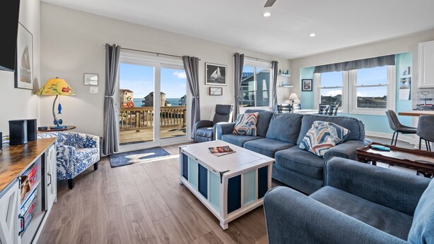 Een moderne woonkamer met een bank, salontafel en plafondventilator.
