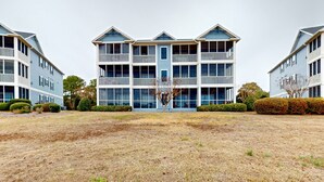 A multi-story building with balconies and a central entrance. - Mystic Marina B: Spacious condo with marina & Intercoastal views, screened-in balconies, W/D & AC (Southport)
