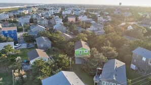 An aerial view of a residential area with houses, trees, and a water tower in the distance.