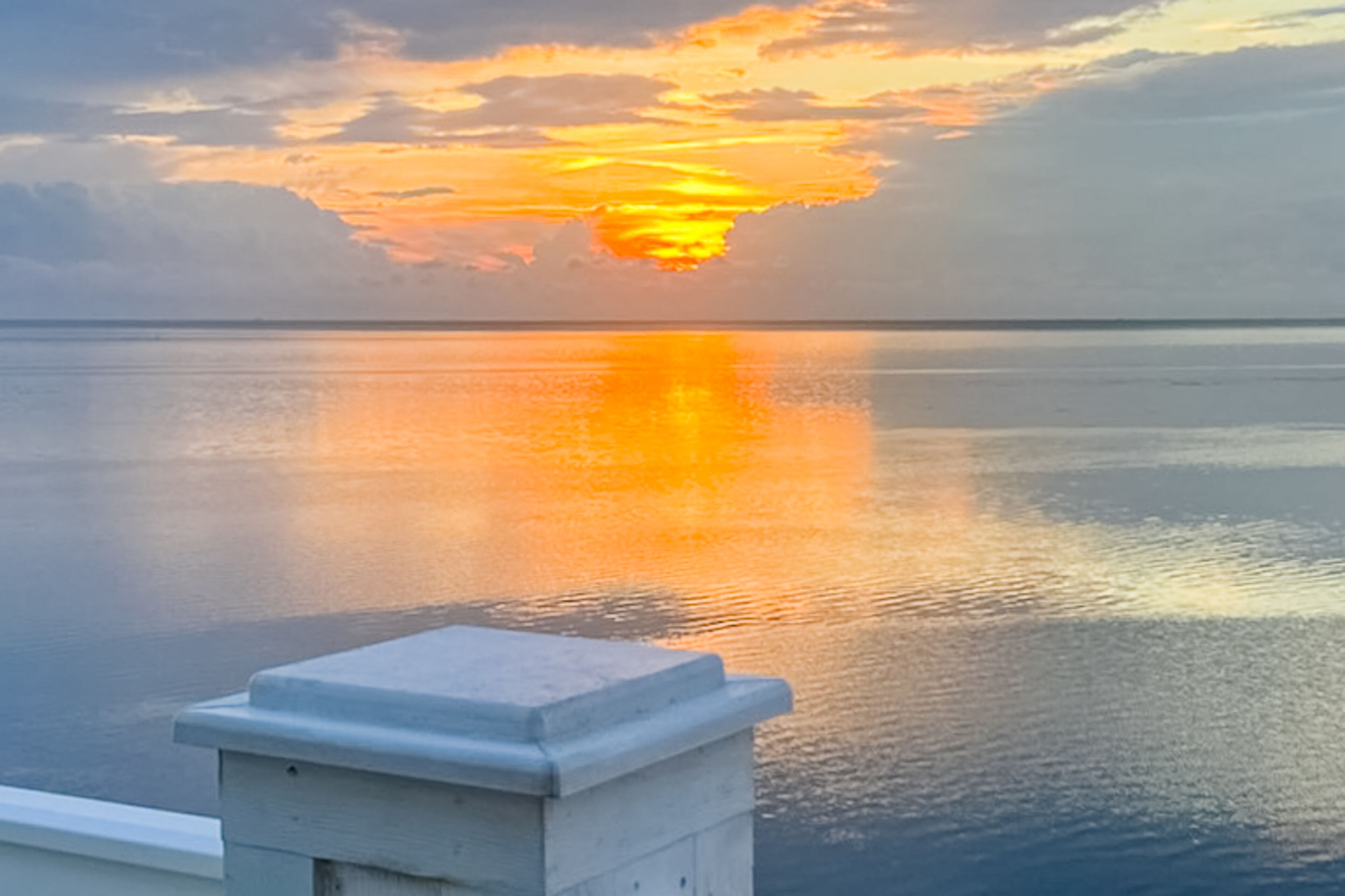 A calm body of water reflecting a sunset.
