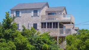 A two-story wooden house with a balcony on the upper floor. - Classic, Dog-Friendly Home w/ AC, Shared Pool, High-Speed WiFi - Steps to Beach (Avon)