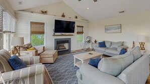 A spacious living room with a fireplace, a ceiling fan, and a large TV. - Waterfront home with private pool, hot tub, pool table & fireplace -dog-friendly (Avon)