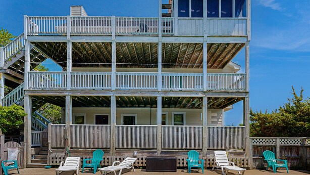 A multi-level wooden building with balconies, outdoor seating, and a staircase. - Waterfront home with private pool, hot tub, pool table & fireplace -dog-friendly (Avon)
