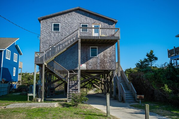 Un bâtiment à deux étages avec un escalier en bois menant à un balcon.